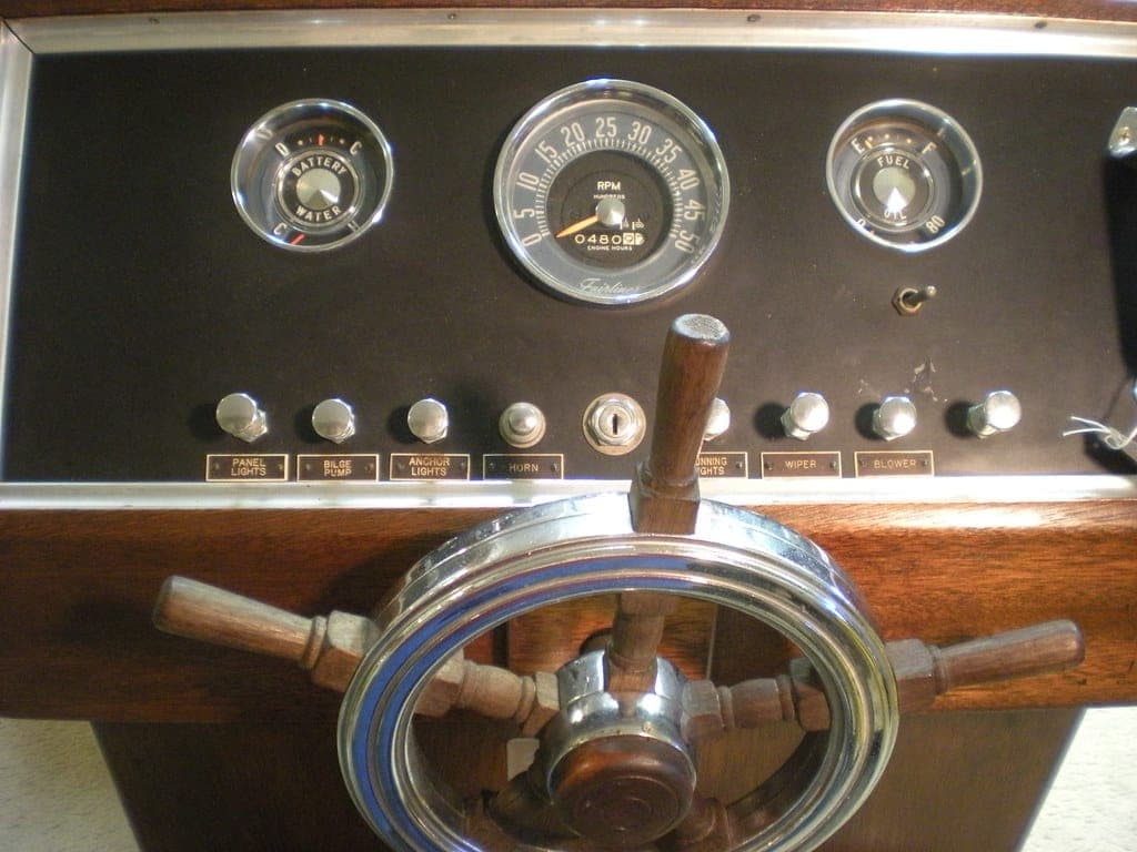 An old wooden boat console with gauges and a ship's wheel